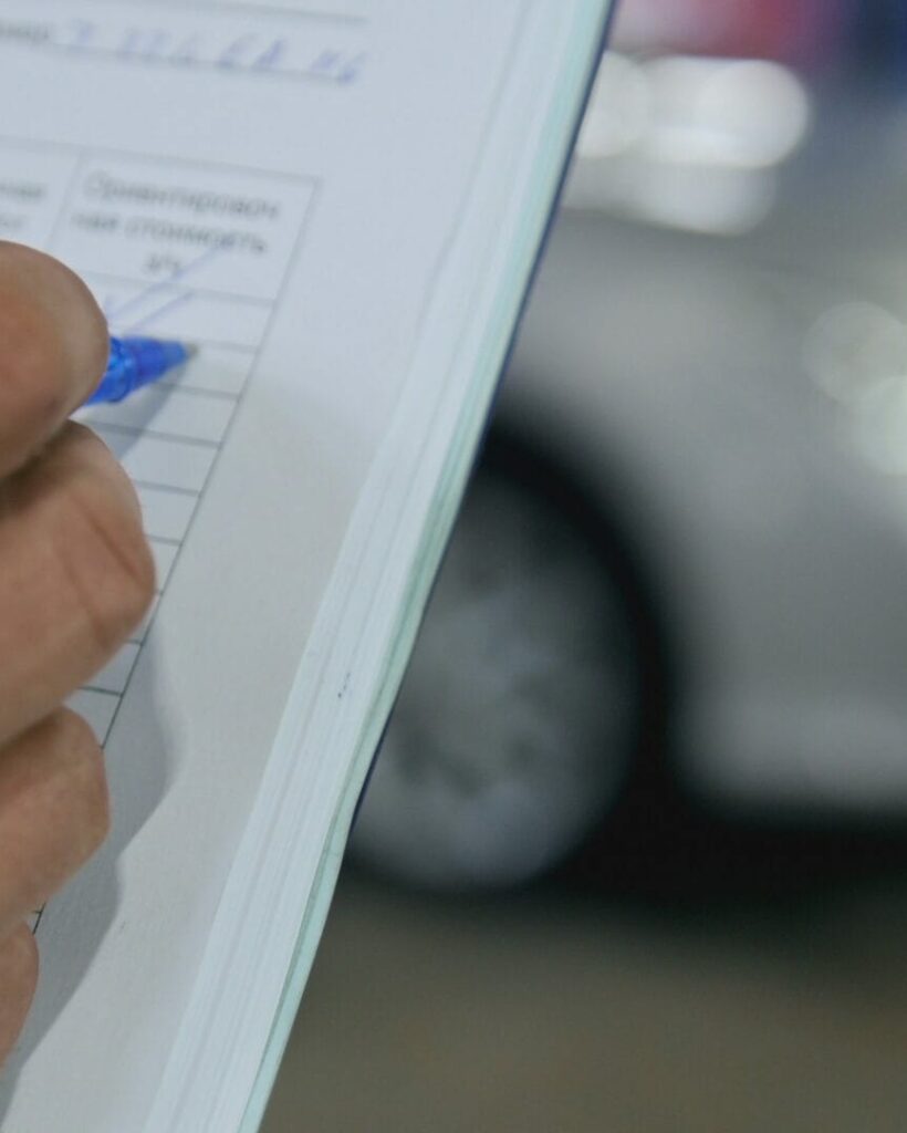 Checkmarks - worker doing checking of a auto parts in a garage workshop, close up